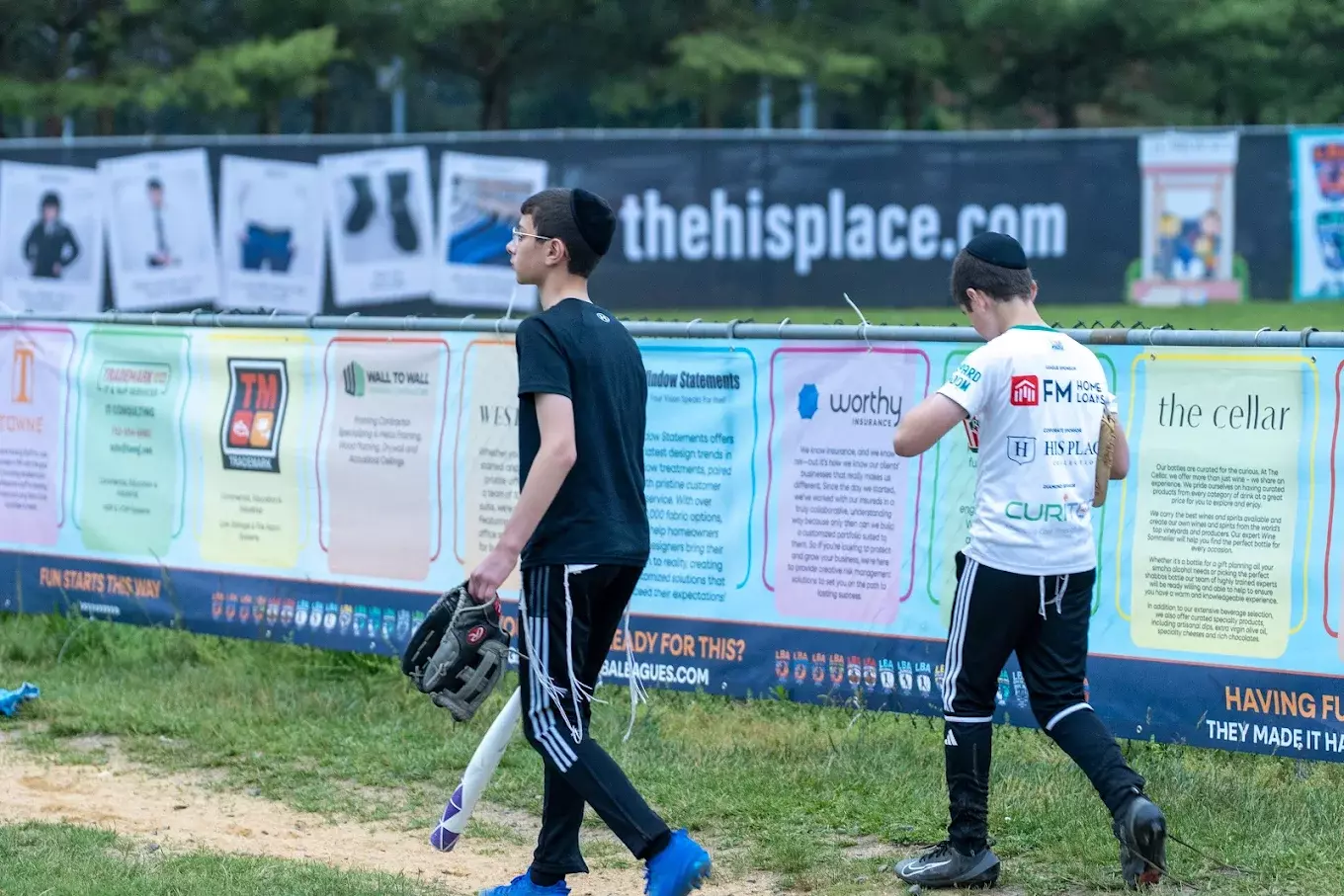 LBA baseball event sponsor banners lining the field fence