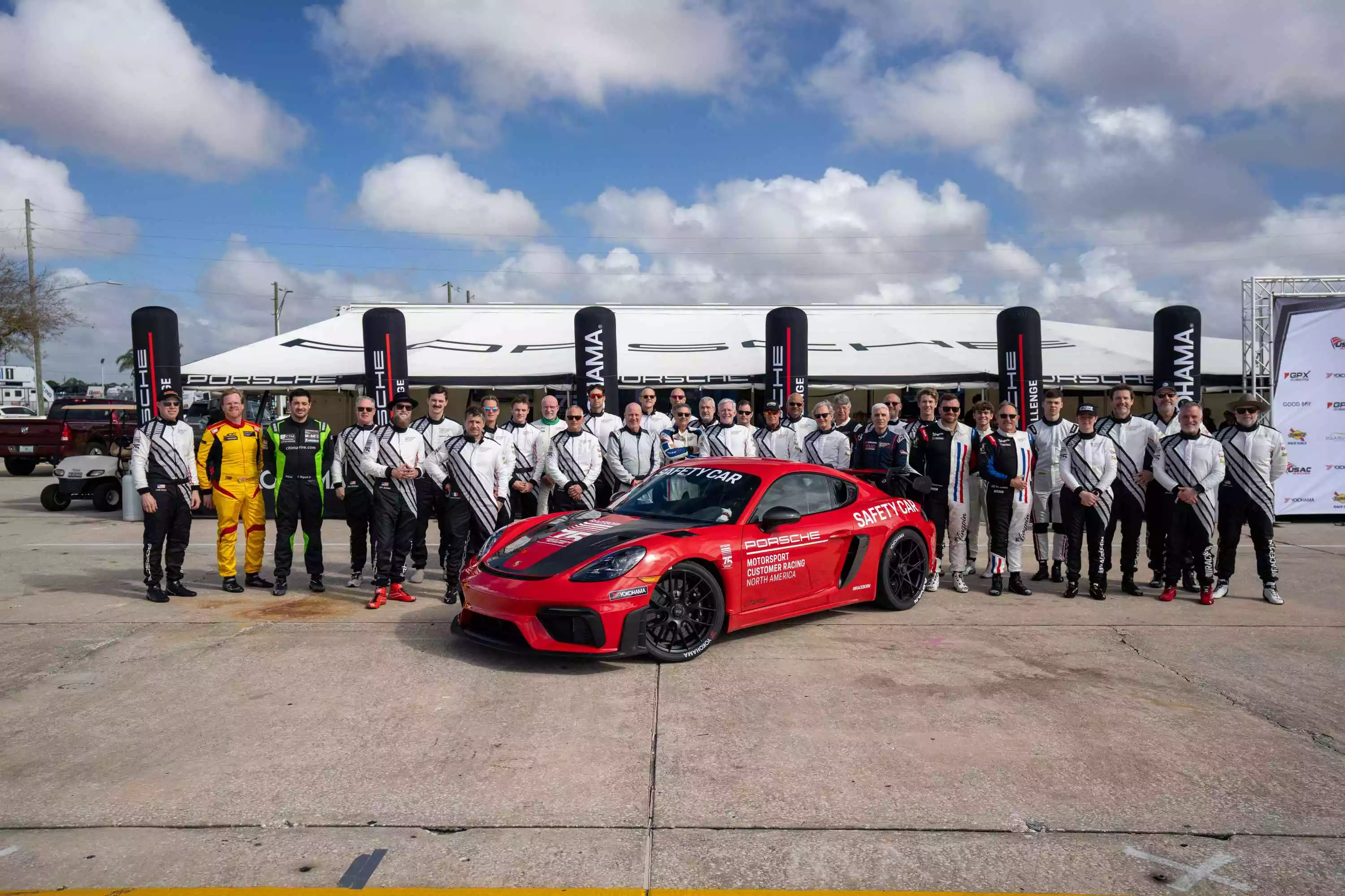 Porsche racing team group photo with safety car